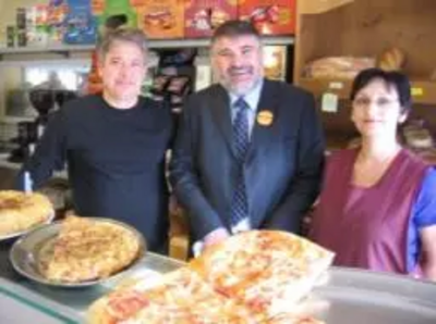 Dave Hodgson behind the bakery counter with Mr and Mrs Vecchio