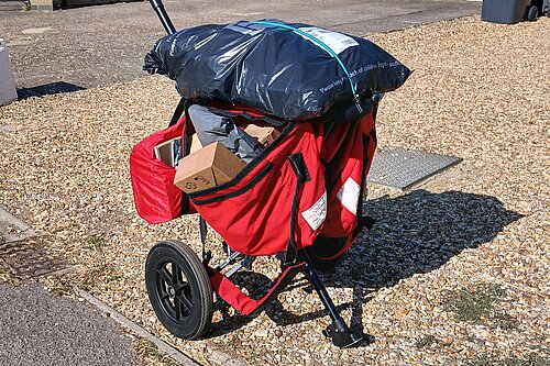 a postal delivery trolley bulging with parcels