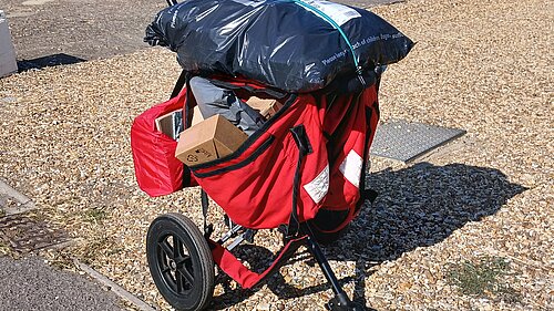 a postal delivery trolley bulging with parcels